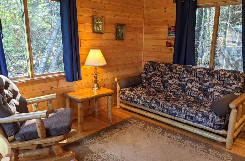 Small living area with a futon and rocking chair.