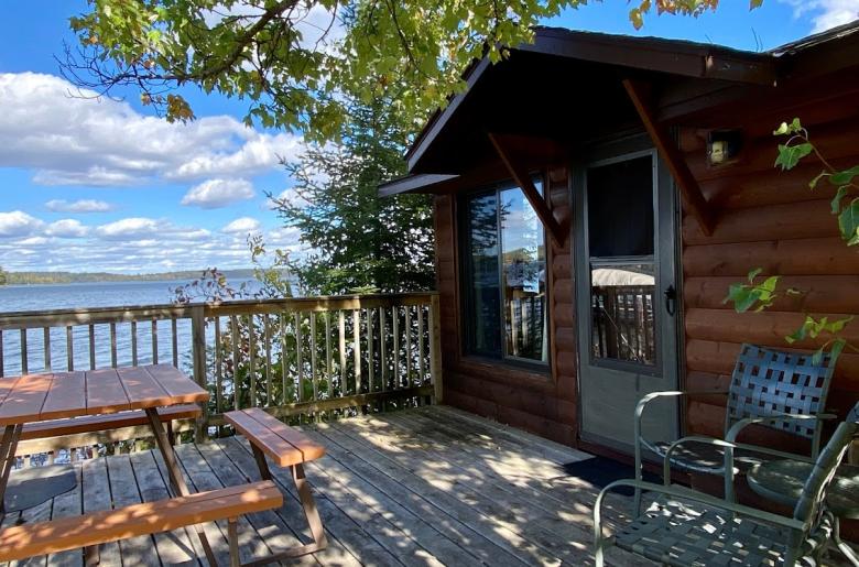 Deck area with picnic table, charcoal grill, and views of the lake.