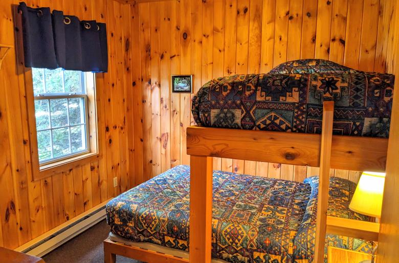 Bedroom with a full size bed and a twin lofted above it.