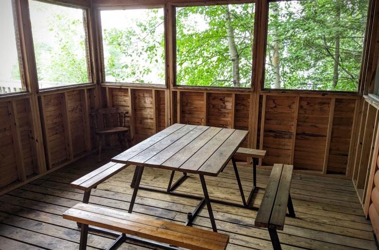 Screen porch with a picnic table.