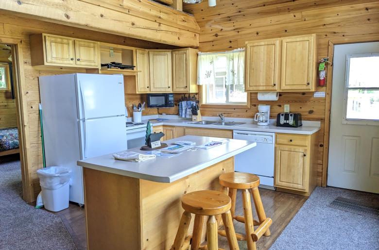 Kitchen with refrigerator, stove, dishwasher, and island seating.