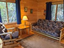 Small living area with a futon and rocking chair.